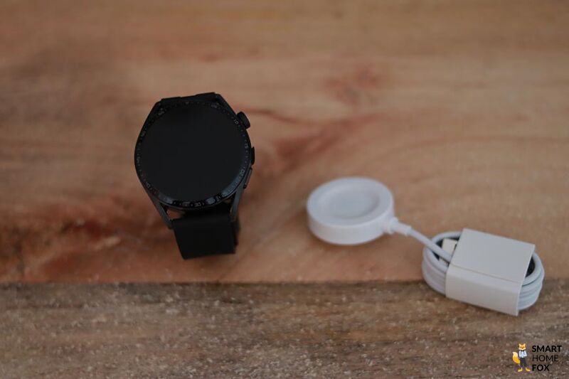 Man sieht die Huawei Watch GT 3 und ihr Ladekabel.